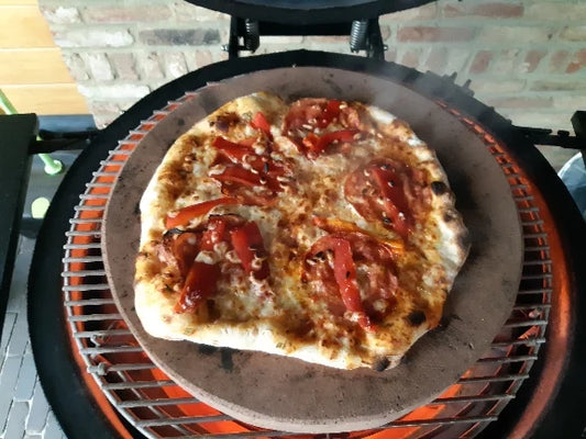 Pizza on pizzastone in kamado